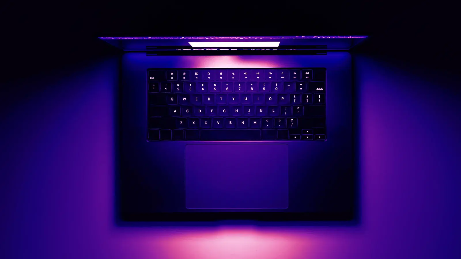 A backlit laptop glowing in a dark room — where it all began